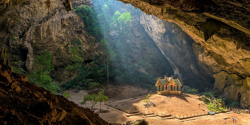 The stunning Phraya Nakhon Cave with sunlight shining on the golden pavilion inside.