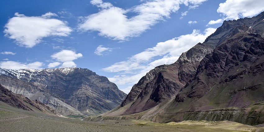Pin Valley National Park with green grass surrounded by mountains slightly covered in snow