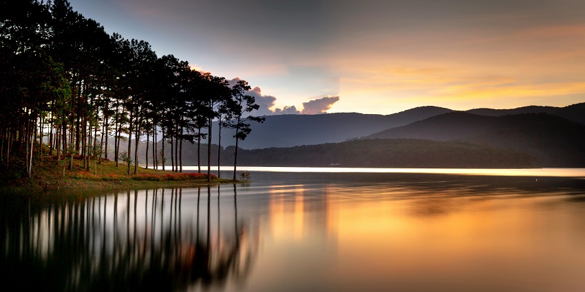 Pocharam Lake with rocky landscapes and grassy texture with sunset hues reflecting in the water