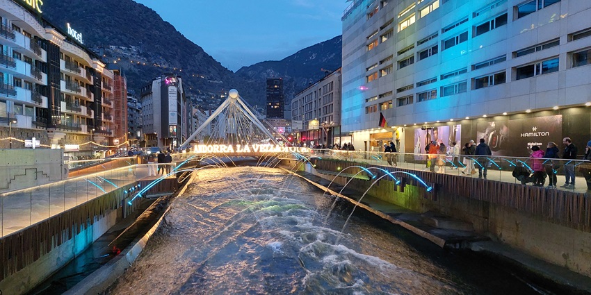 The modern Pont de Paris bridge in Andorra la Vella is illuminated with artistic lighting.