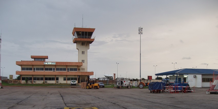 Port Gentil International Airport with tall lights, the airport building and a control tower