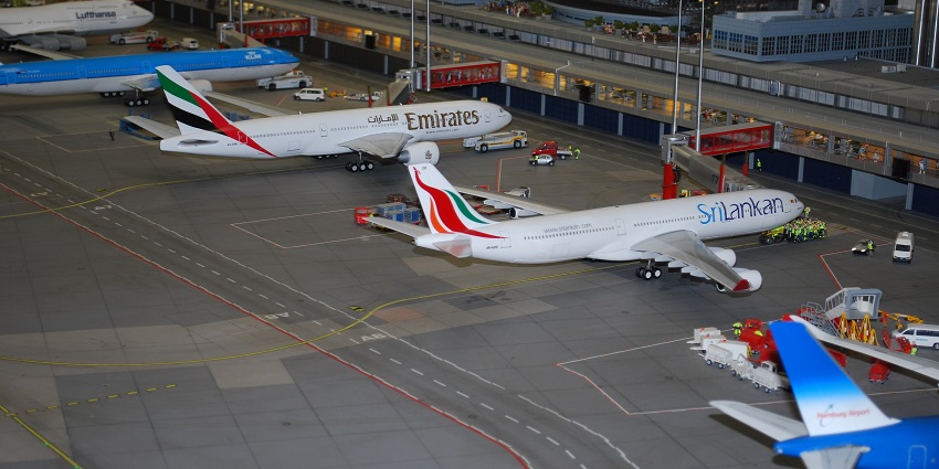 A hangar with many aircraft lined up in rows on both sides and cars are parked below at one of the airports in Sudan.