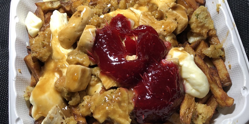 Poutine, which is composed of fries, cheese curds, gravy, stuffing and cranberry sauce.