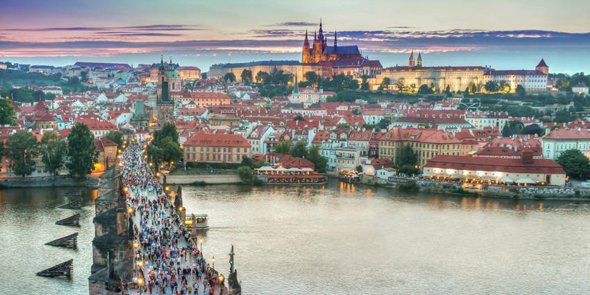 A row of charming European-style buildings stands beneath a cloudy sky in a picturesque view.