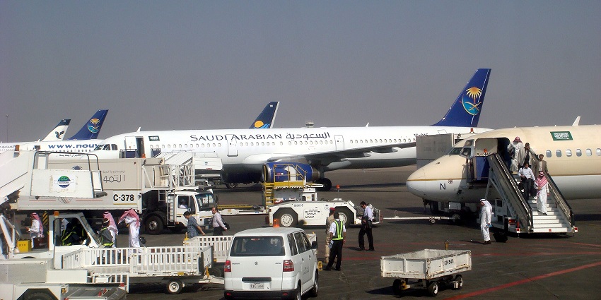 Prince Mohammad Bin Abdulaziz International Airport with multiple aircraft and vehicles parked