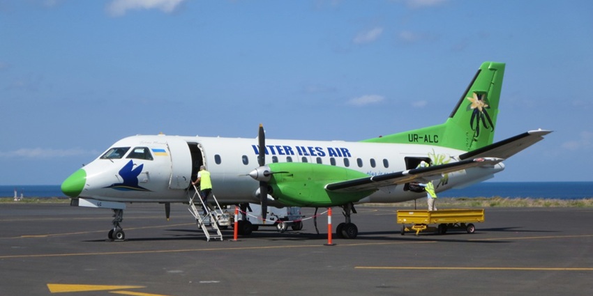 Aeroplane at Prince Said Ibrahim International Airport with a man climbing up the stairs