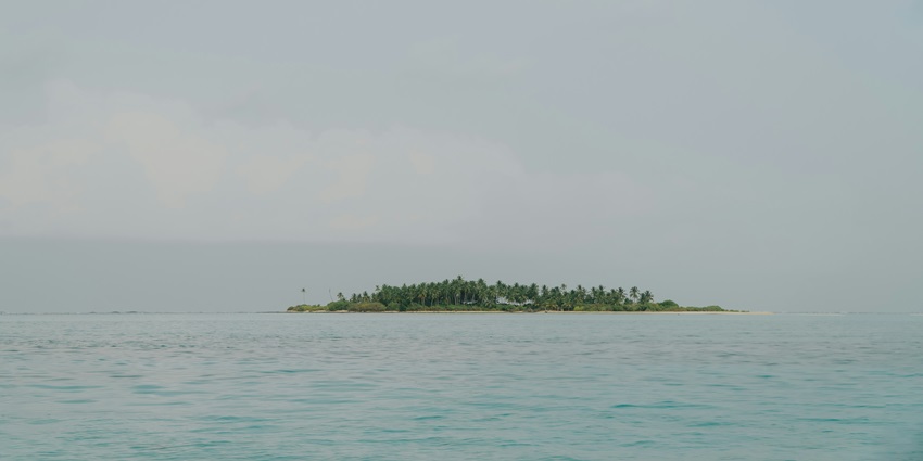 A glimpse of the scenic Pulau Nusa Dharma surrounded by shimmering blue waters.