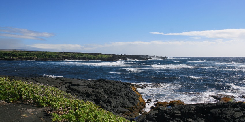 Waves crash onto the jet-black shores of Punaluʻu Beach, one of the most popular black sand beaches in the world.