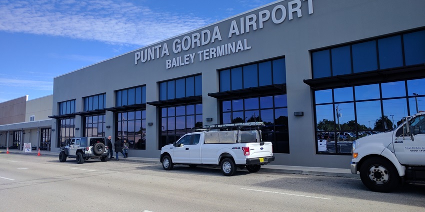 Terminal of Punta Gorda International airport with glass architecture and cars parked