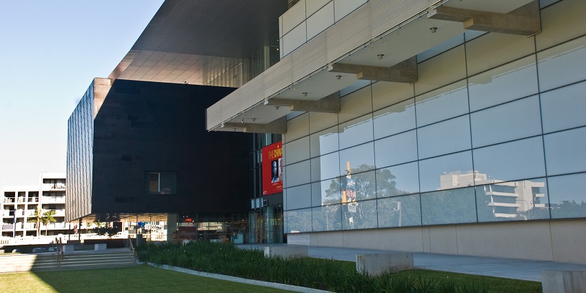 Inside QAGOMA in Brisbane, contemporary art pieces are displayed, and visitors admire the exhibits.