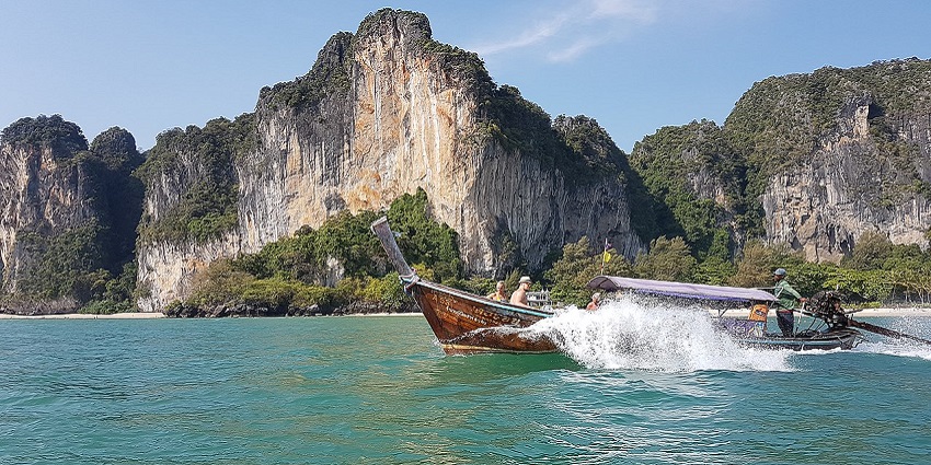 View of West Rai Leh Beach, a tourist attraction near Krabi, with sand and cliffs.