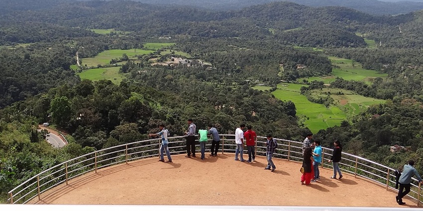 Tourists enjoy views of a vast expanse of lush greenery from the Raja’s Seat in Madikeri