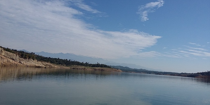 An image of Ranjit Sagar Dam Lake with vast blue waters and surrounding green hills, a lake in Jammu.