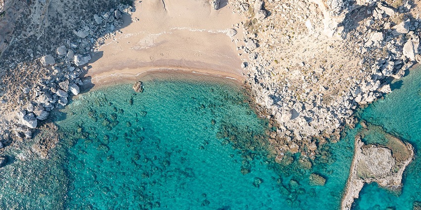 Famous for its unique reddish sands, clear blue waters, and scenic cliffs
