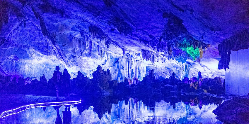 Reed Flute Cave glowing with vibrant lights, showcasing stalagmites and stalactite caves