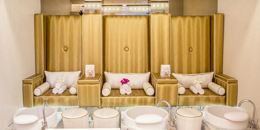 A spa setup featuring a massage table, pink flowers, and candles in Napier.