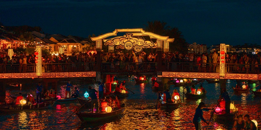 An image of the lanterns floating on a river at night as a couple makes a wish together.