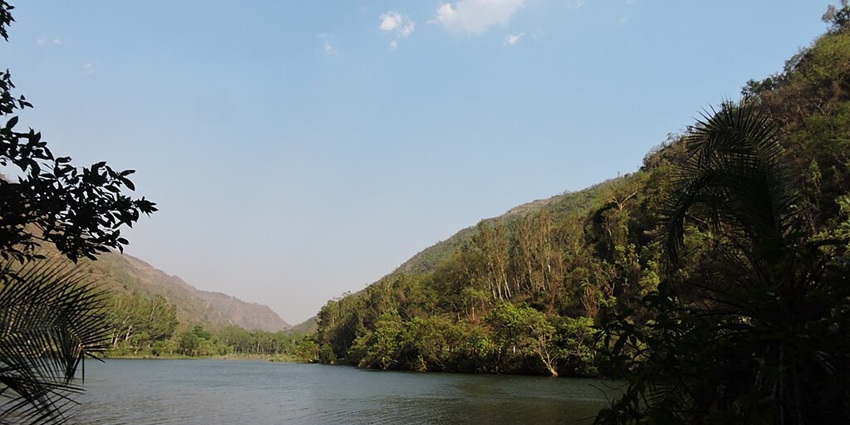 An image of Renuka Lake, a scenic natural waterbody in India, surrounded by high peaks