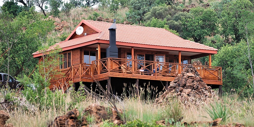 An image of a self-catering log cabin at Rhino and Lion Nature Reserve in South Africa.