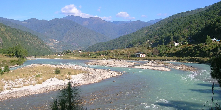 An image of five people rafting on the Mo Chhu and Pho Chhu rivers, wearing helmets, life jackets