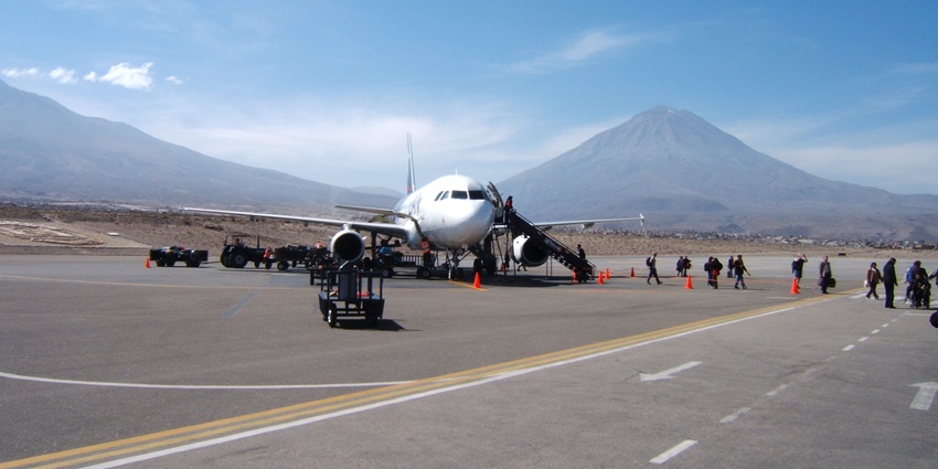 Airplane on the tarmac at Rodríguez Ballón International Airport with majestic volcanoes behind
