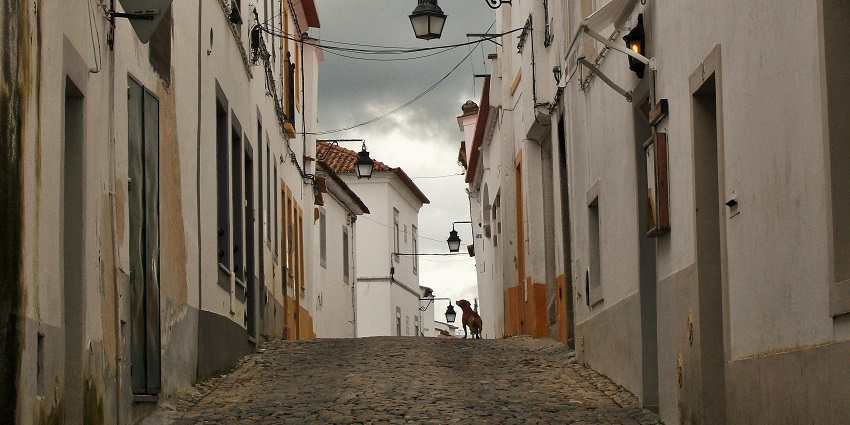 A narrow lane in the majestic city of Evora is looking beautiful under a cloudy sky