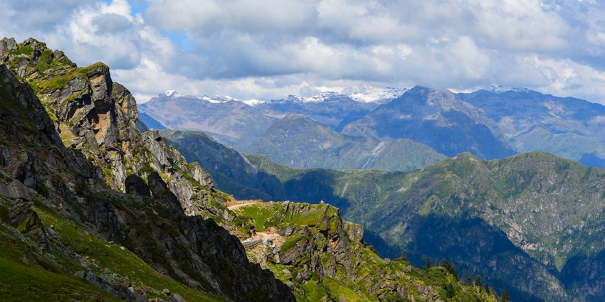 A trekker crossing a high-altitude snowy path on Rupin Pass, a stunning spot for trekking.