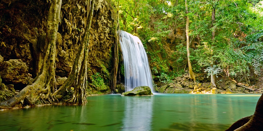 A beautiful waterfall inside Sai Yok National Park in Kanchanaburi, Thailand, surrounded by nature.