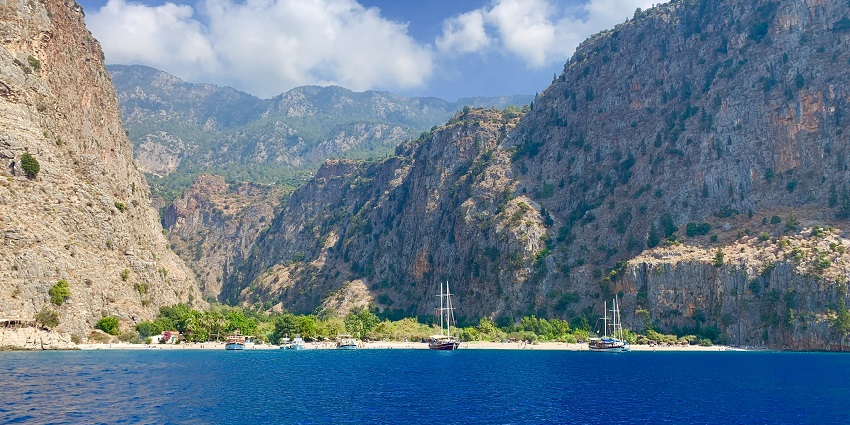 An image of Butterfly Valley in Fethiye, Turkey, with turquoise waters and lush cliffs, showcasing Things To Do in Fethiye.
