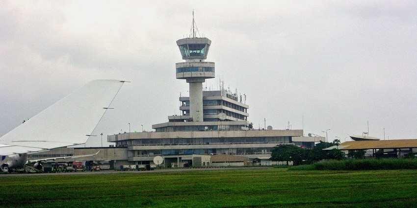 Nigerian airport in Nigeria with a spacious terminal, open green field, and a clear sky in the background