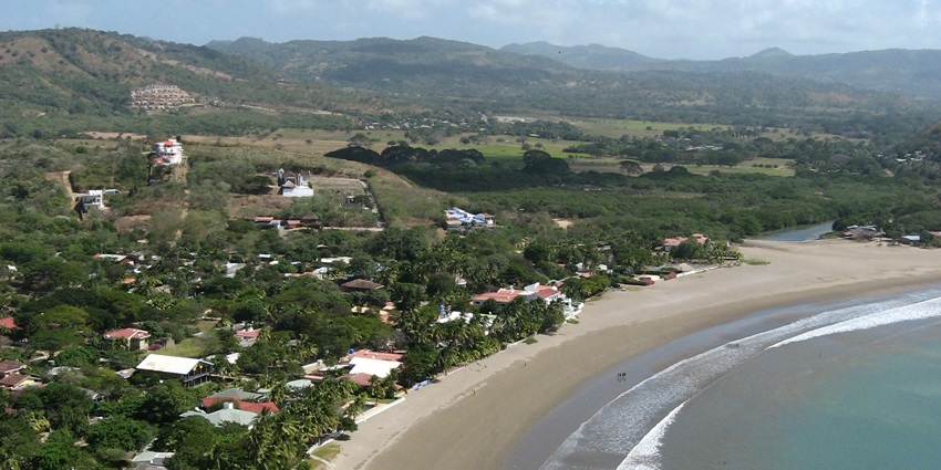 San Juan del Sur’s coastline stretches along the bay, with boats floating on the water.