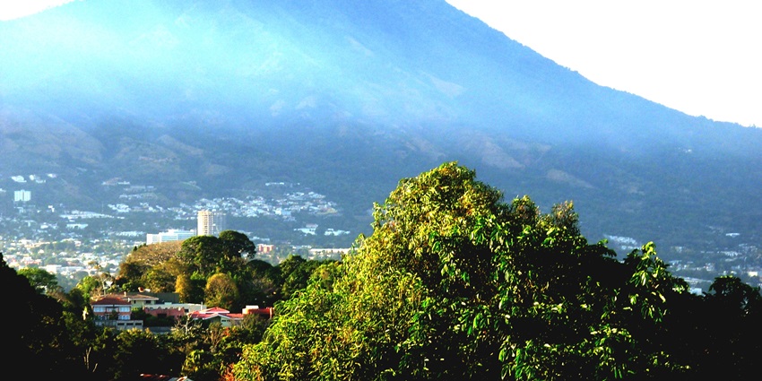 San Salvador Volcano towering over the city while the sunlight is casting shadows on it.