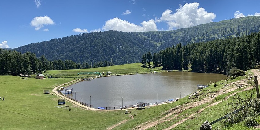 An image of Sanasar Lake with lush green meadows and calm waters, showcasing a lake in Jammu.