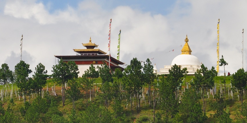 An image of Sangchhen Dorji Lhuendrup Nunnery, with a stupa on a hilltop, golden roof, surrounded by prayer flags