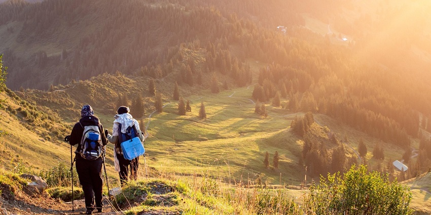 A group of mountaineers trekking along a rugged mountain, surrounded by towering peaks.