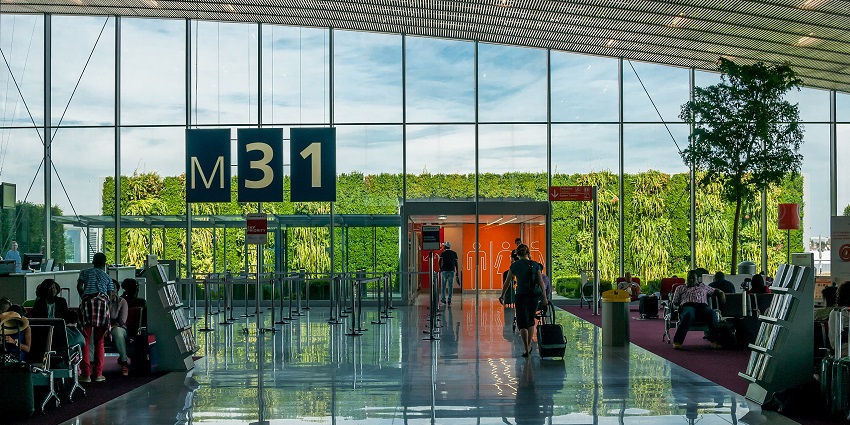 Airport terminal with people carrying their luggage and the glassy surface, one of the airports in Venezuela.