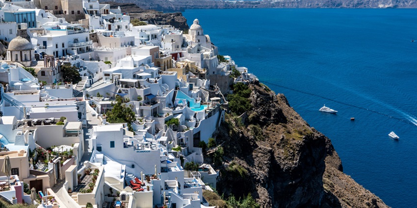 Whitewashed buildings with blue domes - one of the places to visit in Europe in August.