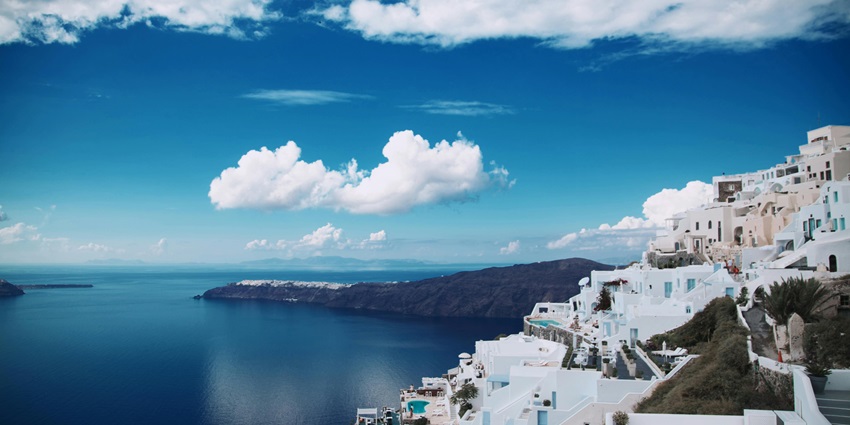 A breathtaking view of Santorini, featuring white-washed houses and a stunning sunset.