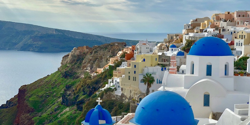 Places to visit in Europe in May include white-washed houses, blue domes, and sunsets.