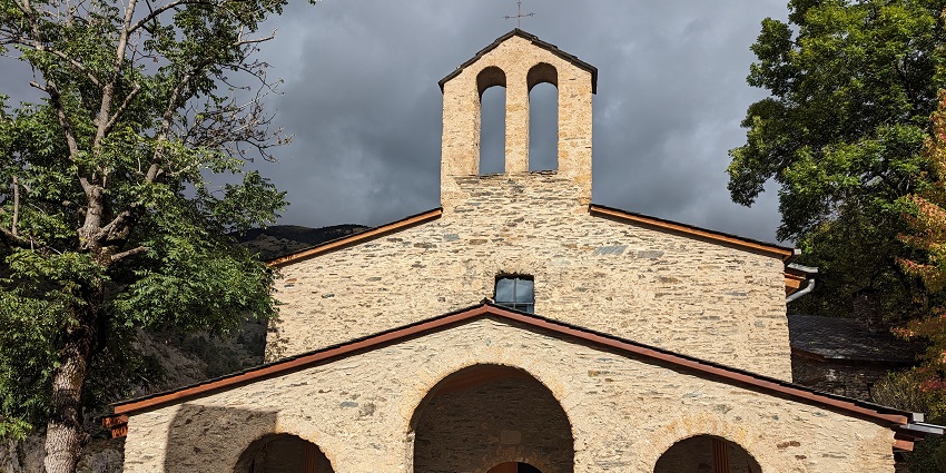 Clouds are gathering above the ancient stone church while sunlight is illuminating it