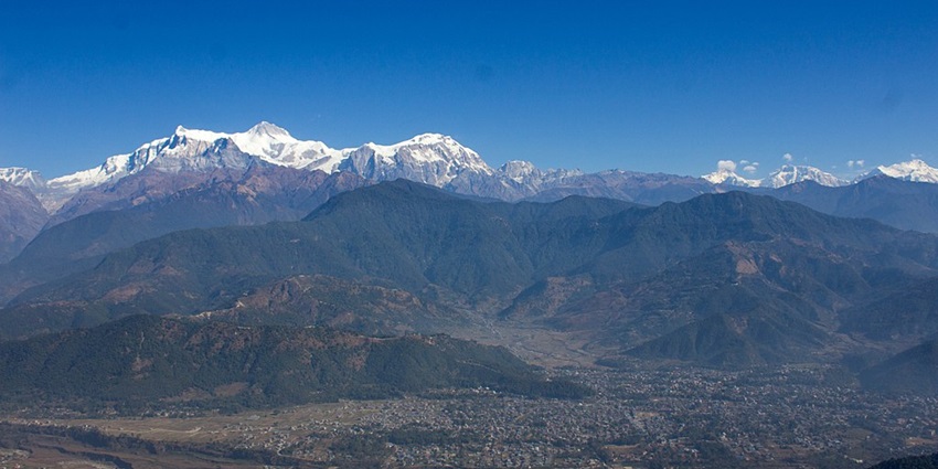 An enchanting vista of Sarangkot Viewpoint featuring majestic mountains and a town.