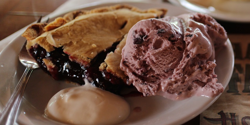 An image of Saskatoon berry pie with a flaky crust and sweet, vibrant berry filling.