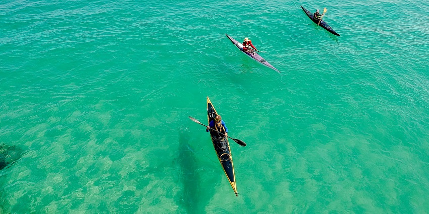 A scenic view of people enjoying kayaking on the turquoise blue waters of Maldives.