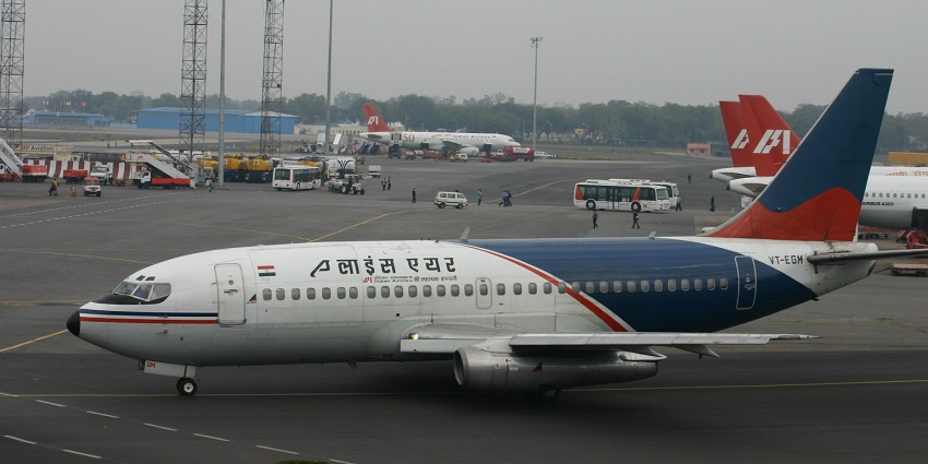 An aircraft parked at a busy airport in Solomon Islands, with connecting buses around.