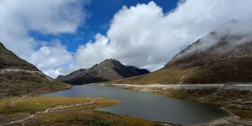 Sela Lake’s water body surrounded by rugged mountains and clouded blue sky above