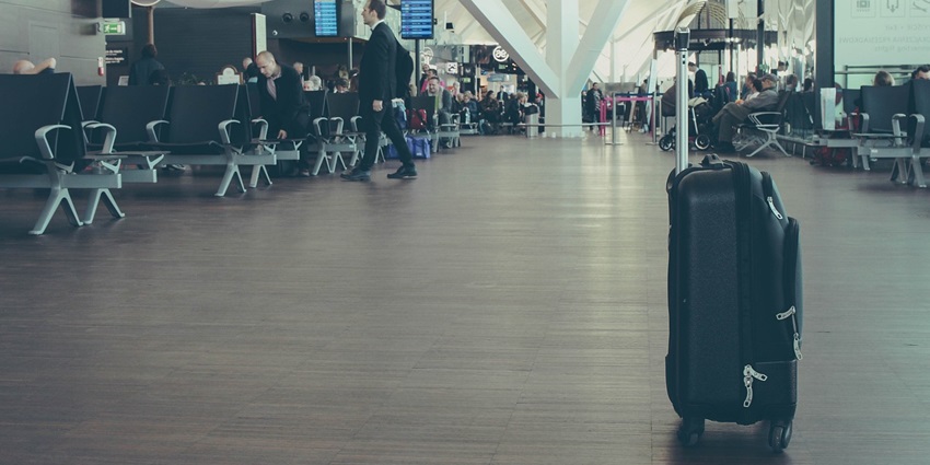 Inside an airport with people walking in the distance and a trolley in the front