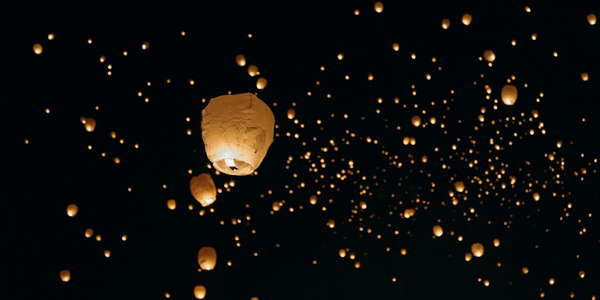 Image of vibrant paper lanterns glowing against a dark sky during a celebration