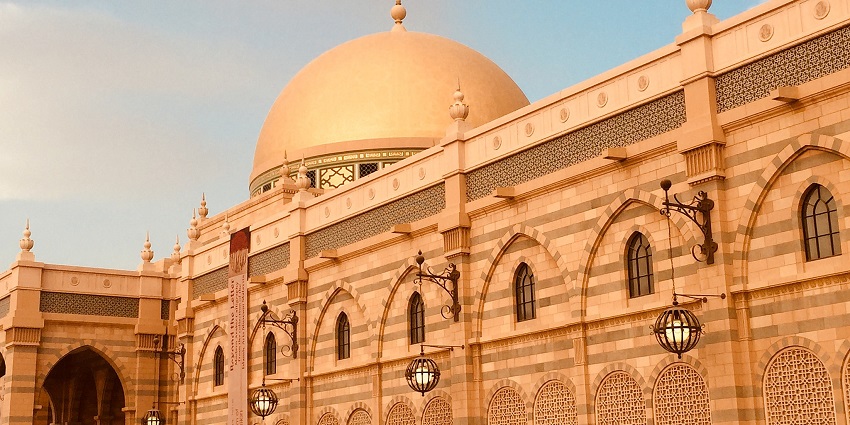The grand exterior of the Sharjah Museum of Islamic Civilisation with its golden dome.