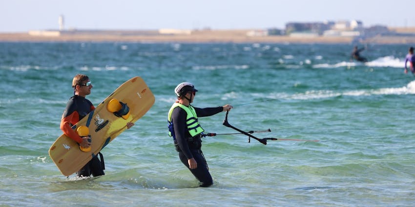 Image of people getting ready for wakeboarding near the body of twitter during day time