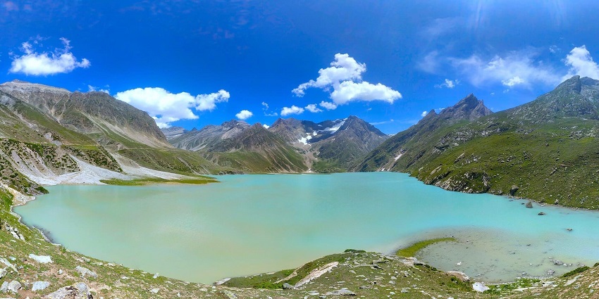 Sheshnag lake with a clear cyan water body, surrounded by rocky and snowy mountains